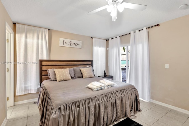 tiled bedroom featuring ceiling fan and a textured ceiling