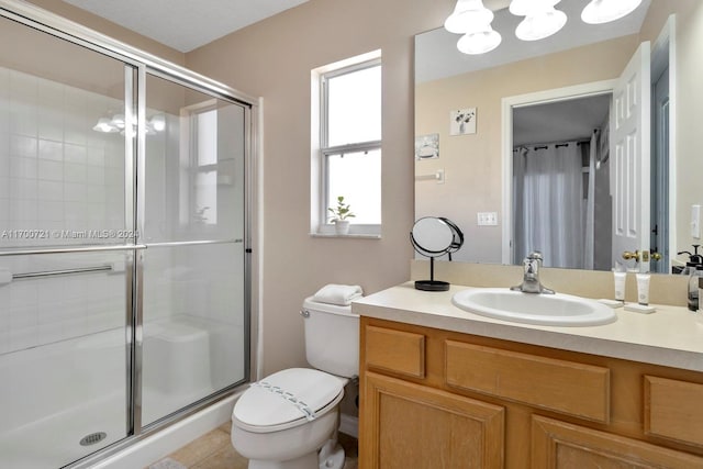 bathroom featuring tile patterned floors, vanity, toilet, and a shower with shower door