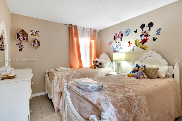 bedroom with light tile patterned floors and a textured ceiling