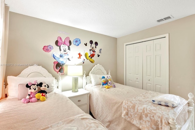 bedroom with carpet flooring, a textured ceiling, and a closet