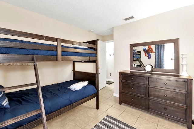 bedroom with light tile patterned floors and a textured ceiling