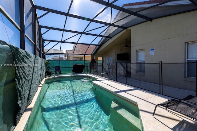 view of pool featuring ceiling fan, a patio area, and a lanai