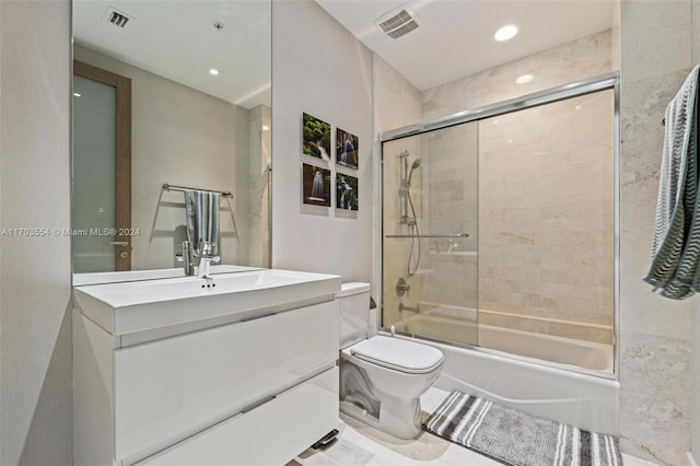 full bathroom featuring shower / bath combination with glass door, vanity, and toilet