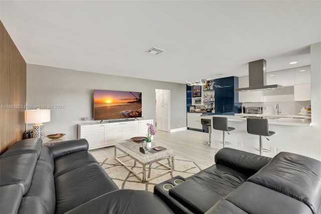 living room featuring light hardwood / wood-style flooring and sink