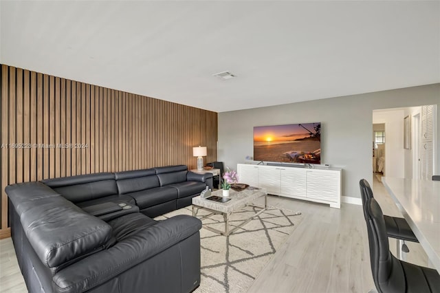 living room featuring light hardwood / wood-style flooring and wooden walls