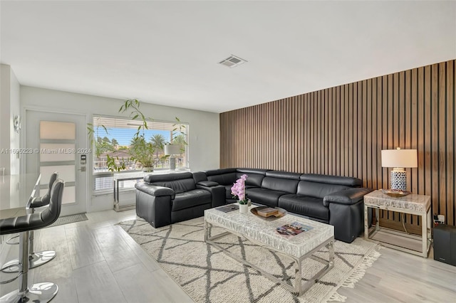 living room featuring wood walls and light hardwood / wood-style floors