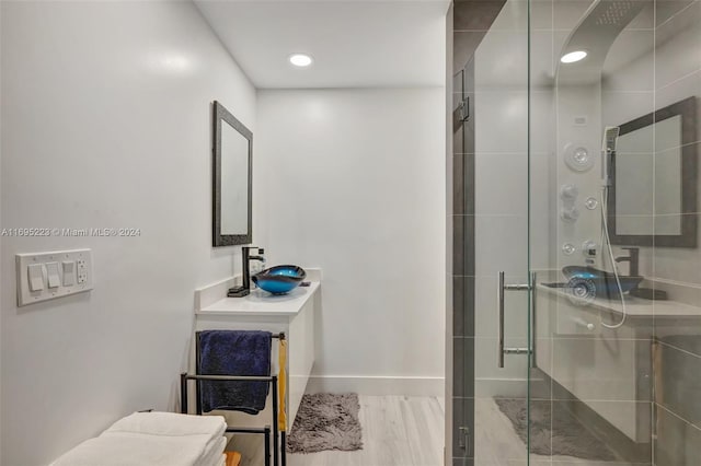 bathroom with hardwood / wood-style flooring and an enclosed shower