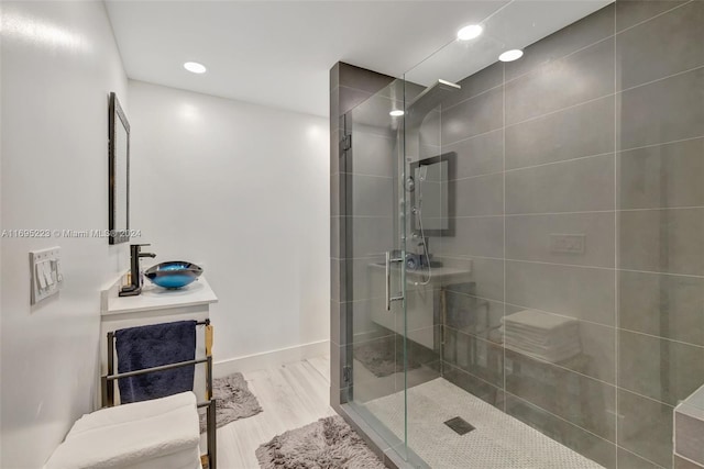 bathroom with hardwood / wood-style flooring, vanity, and an enclosed shower