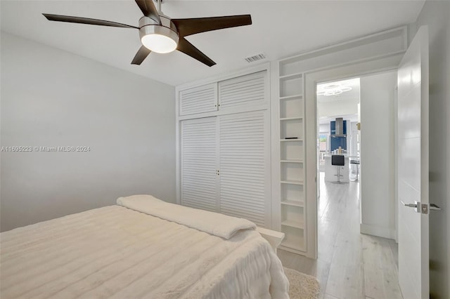 bedroom with a closet, ceiling fan, and light hardwood / wood-style flooring