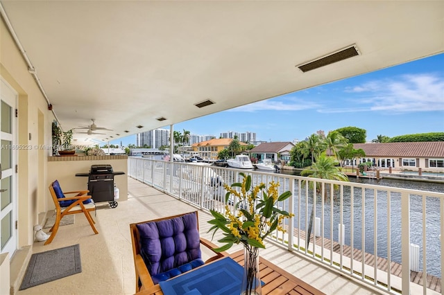 balcony with a grill, ceiling fan, and a water view