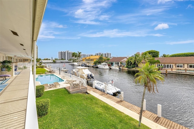 view of pool featuring a patio area, a water view, a yard, and a dock