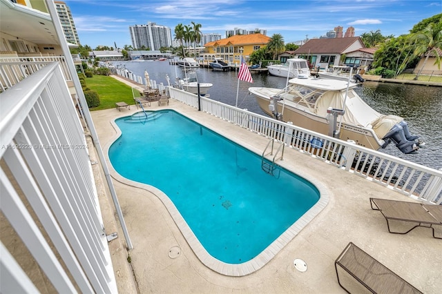 view of pool with a water view and a patio