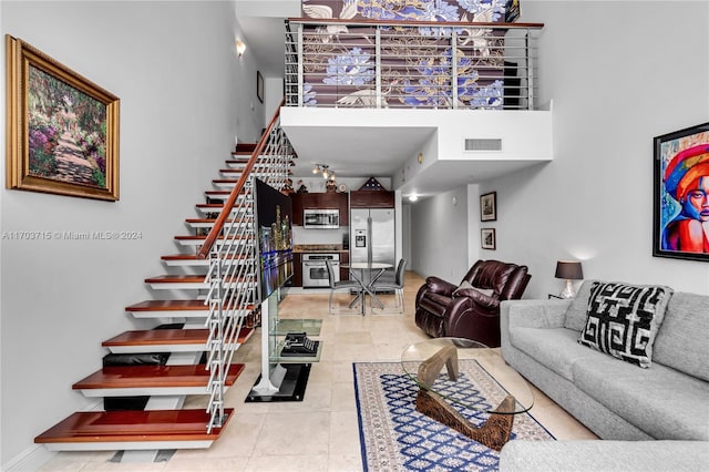 living room featuring a towering ceiling and light tile patterned flooring