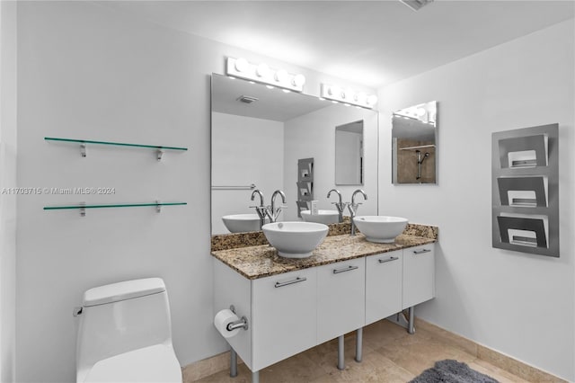 bathroom with tile patterned flooring, vanity, and toilet