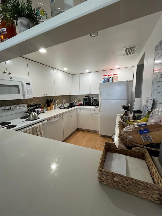 kitchen featuring decorative backsplash, white appliances, sink, light hardwood / wood-style flooring, and white cabinetry