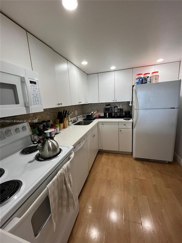 kitchen featuring decorative backsplash, white appliances, sink, light hardwood / wood-style flooring, and white cabinets