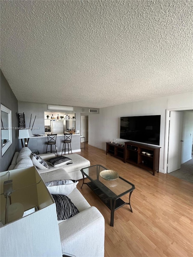 living room featuring a textured ceiling and hardwood / wood-style flooring