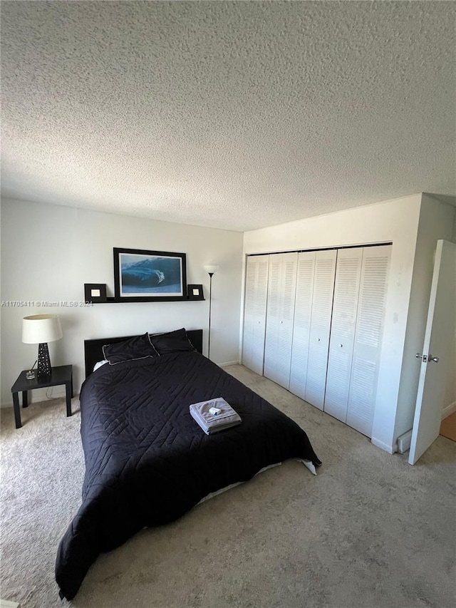 carpeted bedroom featuring a textured ceiling and a closet