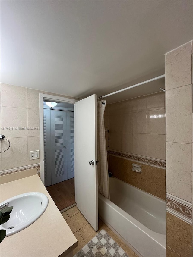 bathroom featuring tile patterned floors, shower / bath combination with curtain, tile walls, and vanity