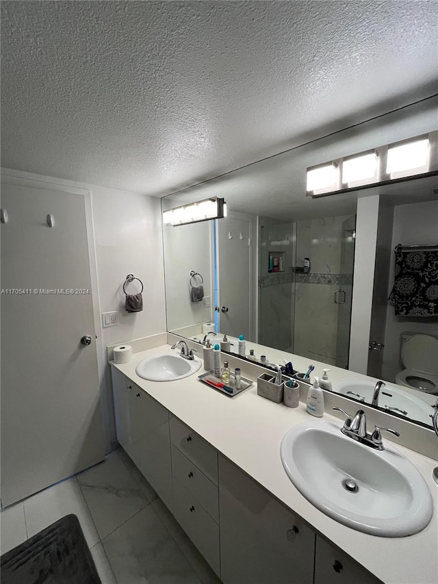 bathroom featuring vanity, a shower with shower door, a textured ceiling, and toilet