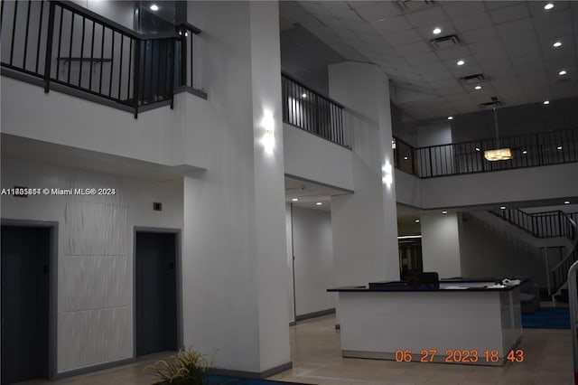 13499 Biscayne Blvd Unit 1601, North Miami, FL 33181 - tiled living area featuring a towering ceiling, elevator, stairway, and a paneled ceiling