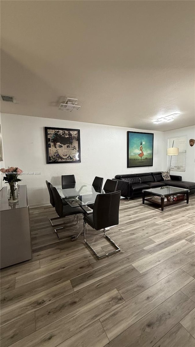 living area with visible vents and wood finished floors