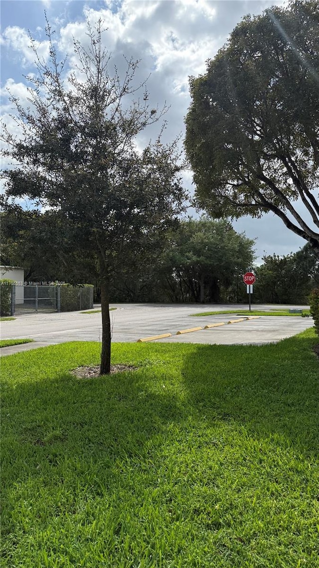 view of yard with community basketball court and fence