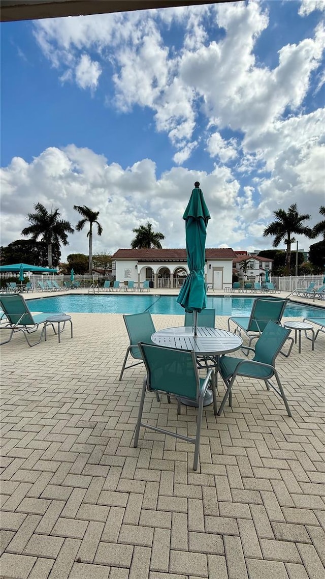 community pool featuring a patio area and fence