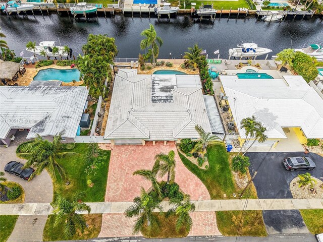 back of house with fence, an outdoor pool, a water view, a patio area, and a residential view