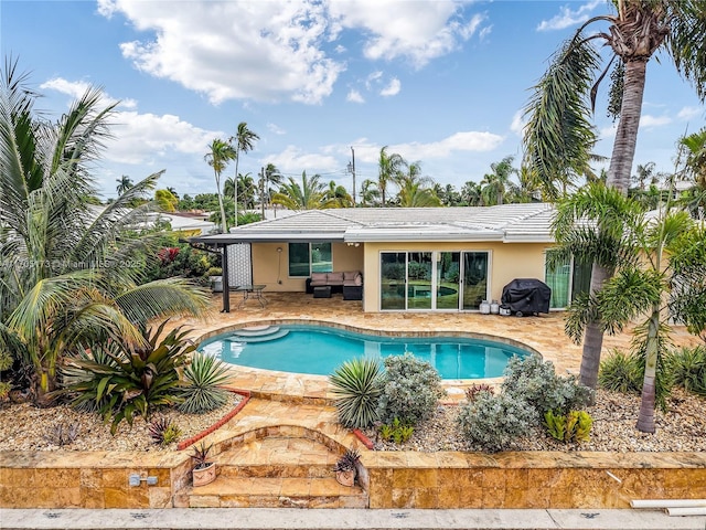 view of pool with an outdoor living space, area for grilling, and a patio