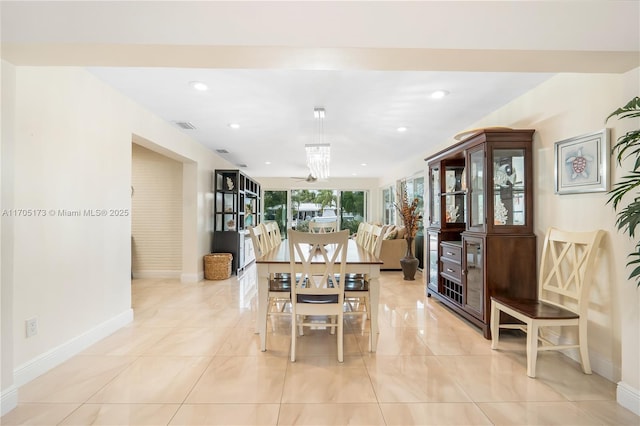 tiled dining room featuring an inviting chandelier