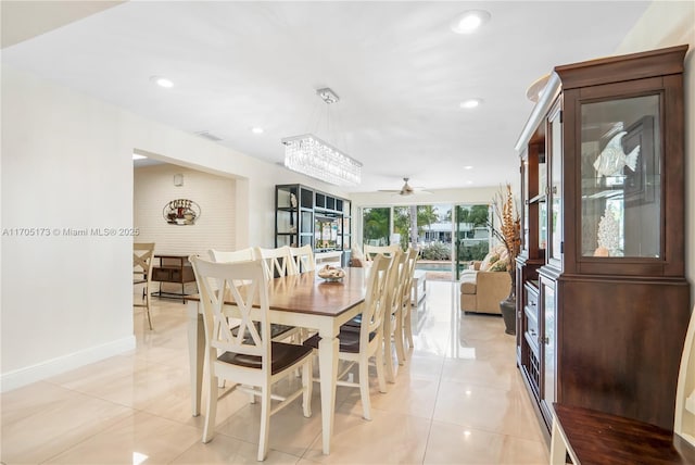 tiled dining area featuring ceiling fan with notable chandelier