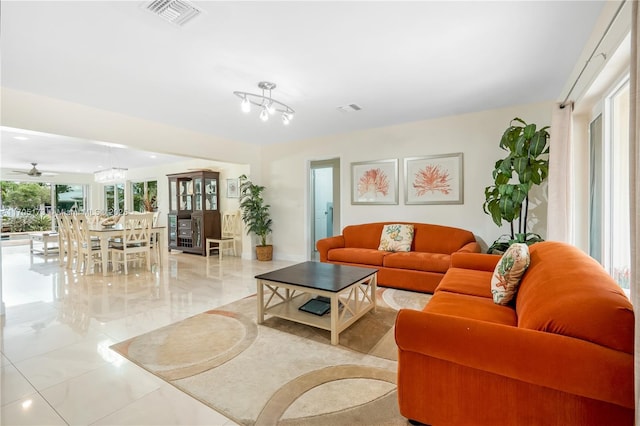 living room with ceiling fan with notable chandelier