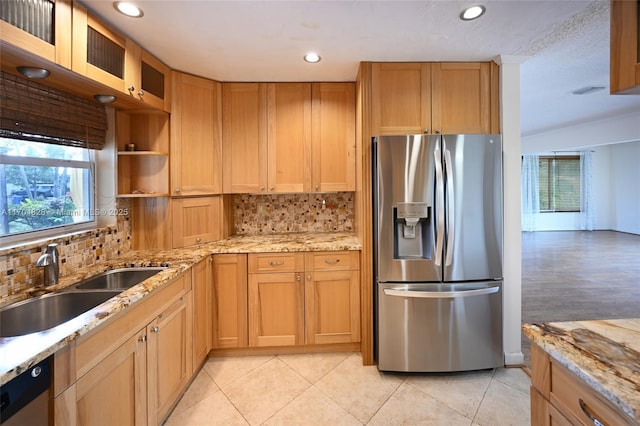 kitchen featuring light stone countertops, appliances with stainless steel finishes, sink, and decorative backsplash