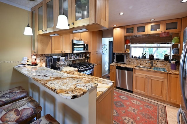 kitchen with kitchen peninsula, appliances with stainless steel finishes, backsplash, hanging light fixtures, and a breakfast bar area