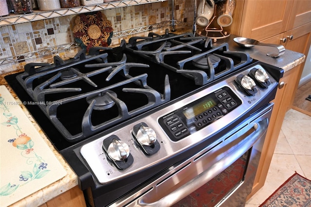 details featuring decorative backsplash and gas stove