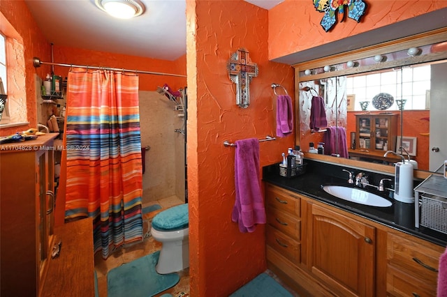 bathroom with curtained shower, vanity, and toilet