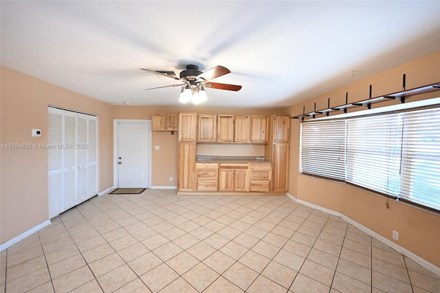 kitchen featuring ceiling fan and light brown cabinetry