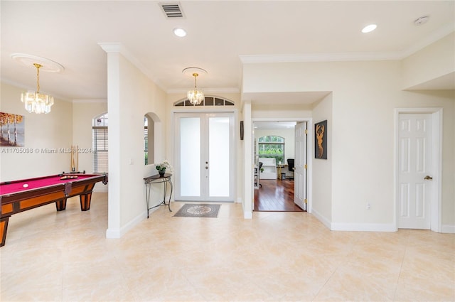 entryway with french doors, crown molding, an inviting chandelier, and pool table