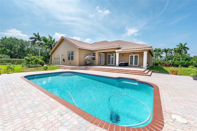 view of pool featuring cooling unit, french doors, and a patio area