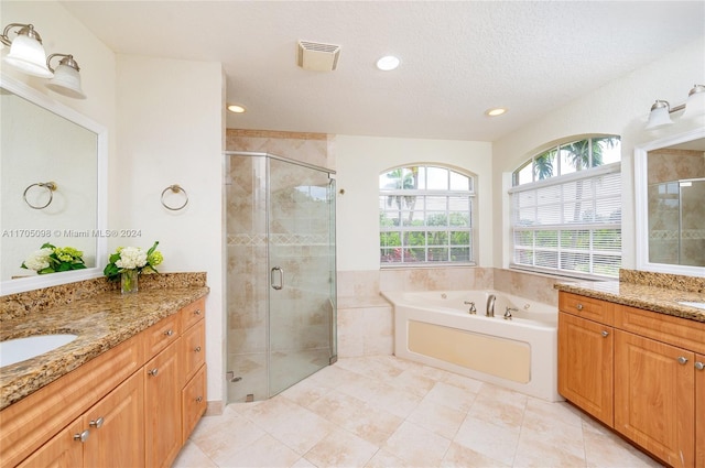 bathroom with a textured ceiling, vanity, separate shower and tub, and tile patterned flooring