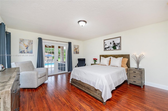 bedroom featuring french doors, dark hardwood / wood-style floors, access to outside, and a textured ceiling