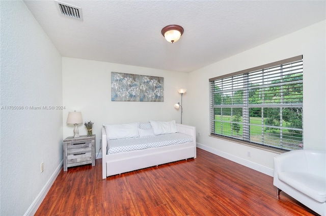 unfurnished bedroom with a textured ceiling and dark hardwood / wood-style flooring