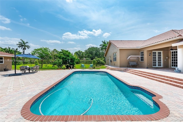 view of swimming pool featuring a patio area and french doors