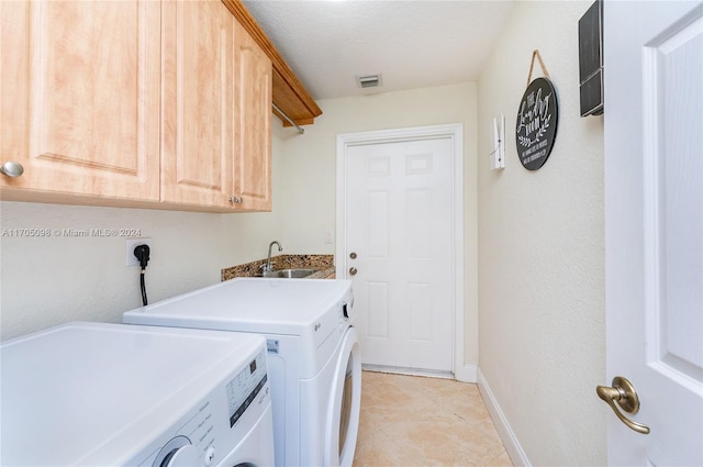 clothes washing area featuring sink, light tile patterned flooring, cabinets, and independent washer and dryer