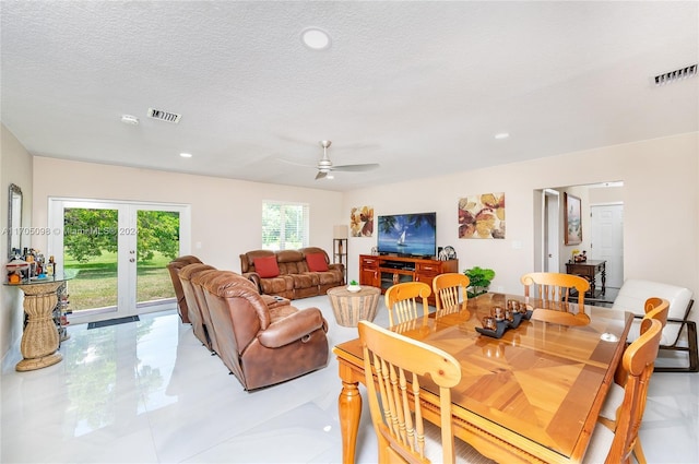 dining area with a textured ceiling, light tile patterned floors, ceiling fan, and french doors