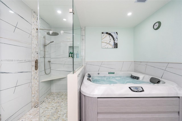 bathroom with tile walls and a tile shower