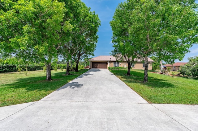 single story home featuring a garage and a front lawn