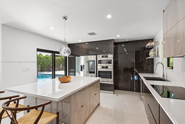 kitchen with a center island, hanging light fixtures, stainless steel appliances, a breakfast bar, and light tile patterned flooring