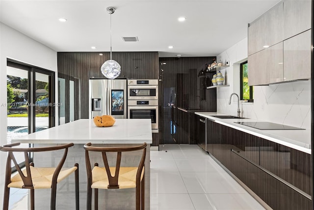 kitchen featuring pendant lighting, a kitchen breakfast bar, plenty of natural light, and appliances with stainless steel finishes